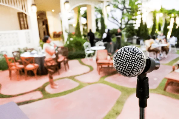Microphone on a stand in front of a softly focused event reception area
