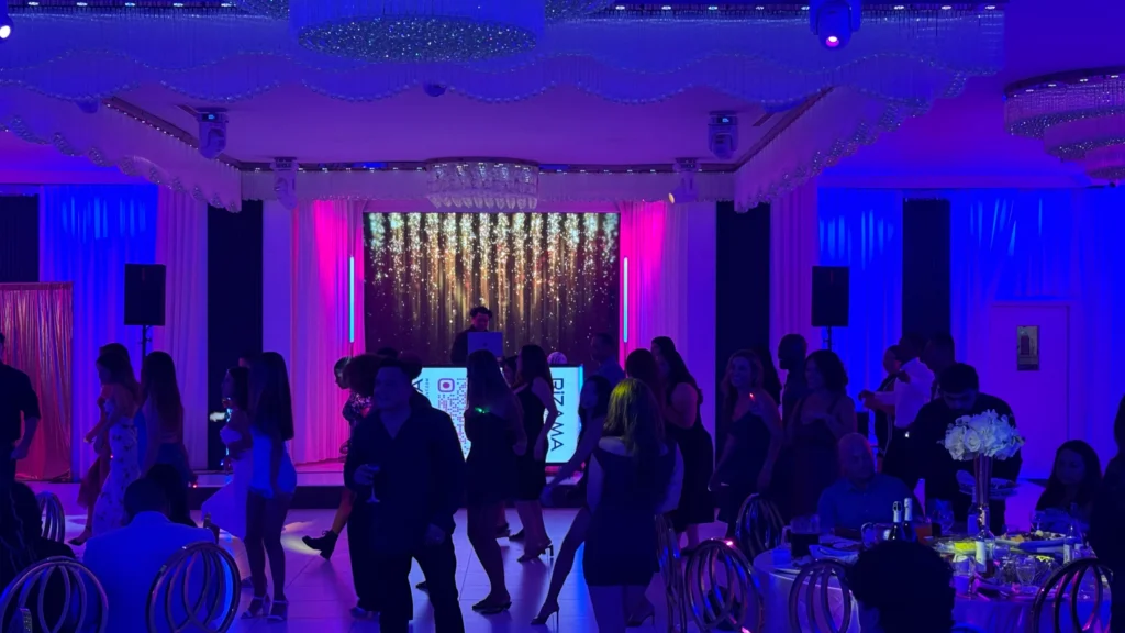 Guests dancing under blue and purple DJ lighting at a Los Angeles party