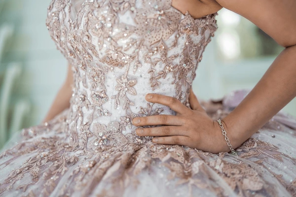 Close view of detailed floral beading and sequins on a quinceañera dress