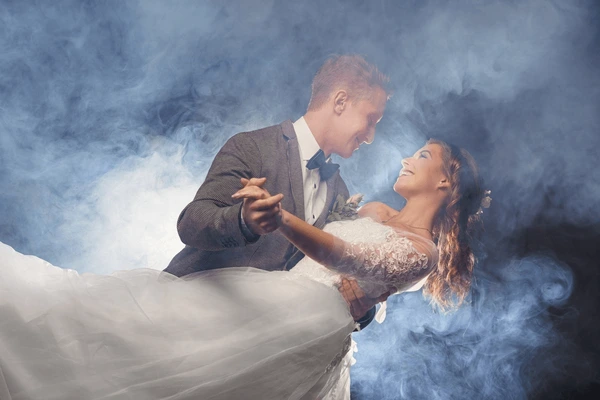 Bride and groom dancing together surrounded by a low fog special effect